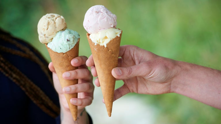 Two hands holding ice cream cones